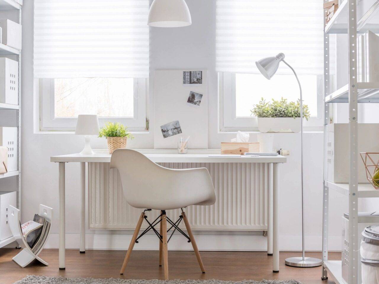 White chair and desk against a wall with two big windows